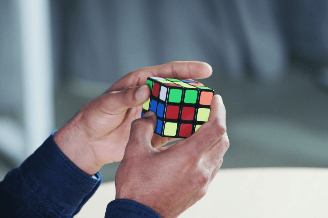 A competitor attempting to speed-solve a rubix cube at a speed cubing competition.