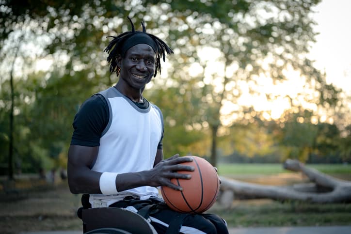 A Scorado Profile picture of a black person playing wheelchair basketball.